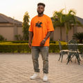 Nigerian male model wearing orange warrior on horseback sketch graphic oversized tee – front view
