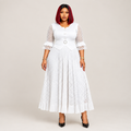 Black Nigerian model wearing a white geometric openwork gown with ruffle sleeves and a belted waist