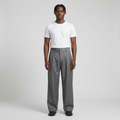 Full-body male model wearing grey pleated wide-leg trousers