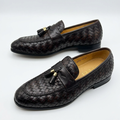 Pair of dark brown basket-weave tassel loafers on a white background