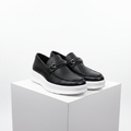 Men's all-black pebbled leather platform loafers with metal bar detail pair product shot
