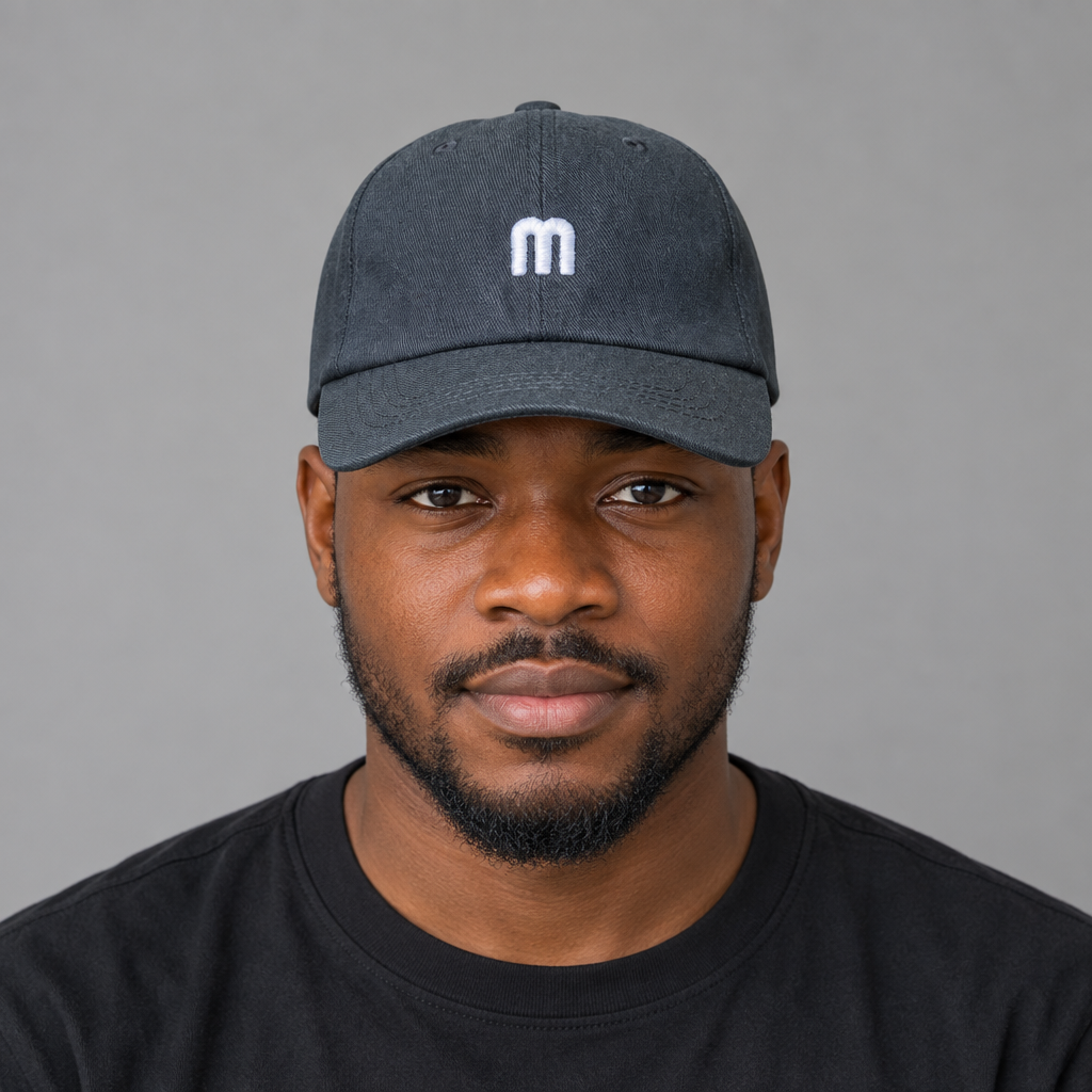 Adult model wearing charcoal baseball cap with small white embroidered detail