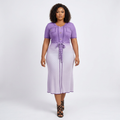 Black female model wearing a lilac ombré belted midi dress on a plain background