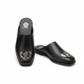 Black leather lion badge half shoe mule ghost mannequin product shot, plain white background