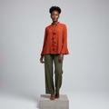 Nigerian female model wearing burnt orange ruffle long-sleeved blouse