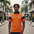 Young Nigerian male model wearing orange colour block polo shirt, front view, Nigerian urban background