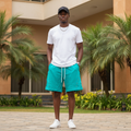 Nigerian male model wearing vibrant teal snap-detail distressed sweat shorts — full body streetwear shot