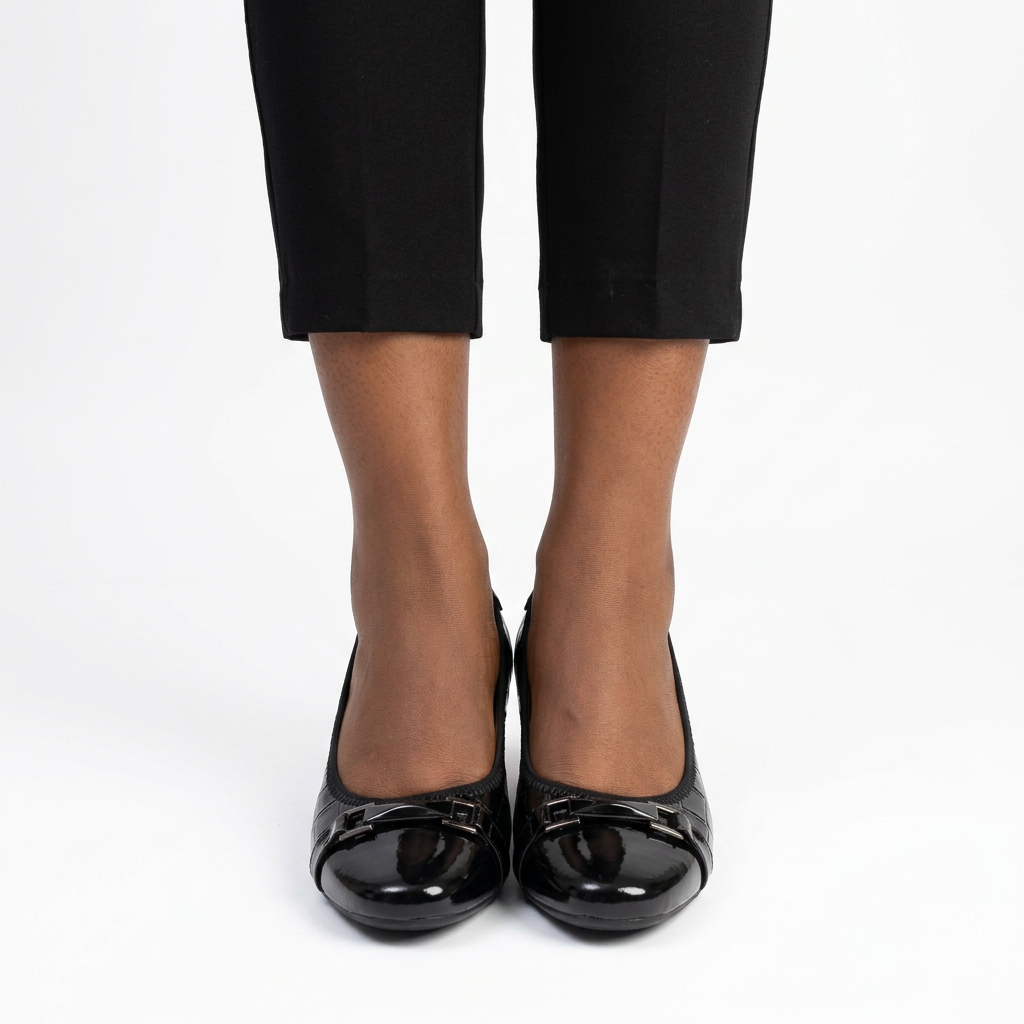 Adult woman wearing black buckle-strap wedges with feet together