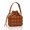 Cognac circle-appliqué drawstring bucket bag on white background