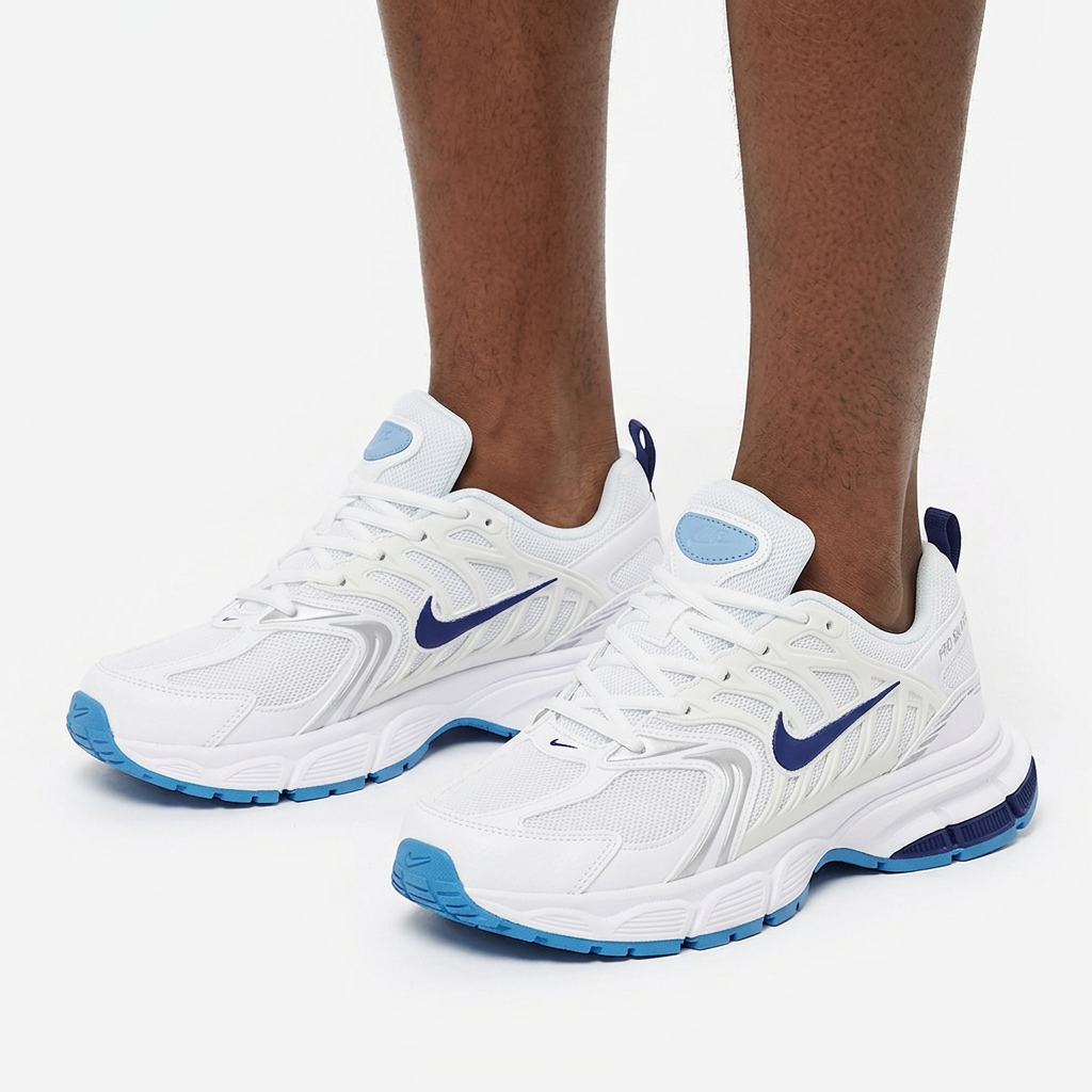 White and blue sneakers worn on both feet by a Black male model on a white background