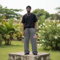 Nigerian male model wearing black and white striped wide-leg sweatpants – full body lifestyle shot