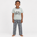 Child wearing bicycle-print pyjama set on plain studio background
