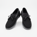 Black perforated suede boat shoes with grey sole, centred on a plain off-white background