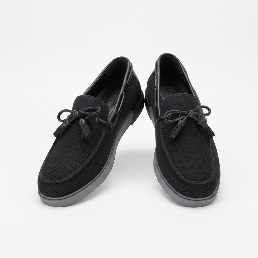 Black perforated suede boat shoes with grey sole, centred on a plain off-white background
