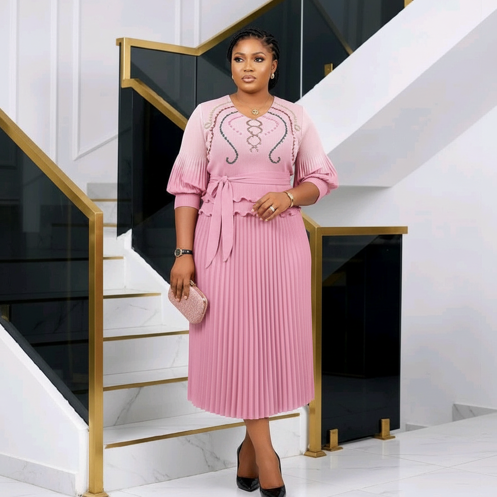 Nigerian woman wearing dusty pink embroidered balloon sleeve top and pleated midi skirt set