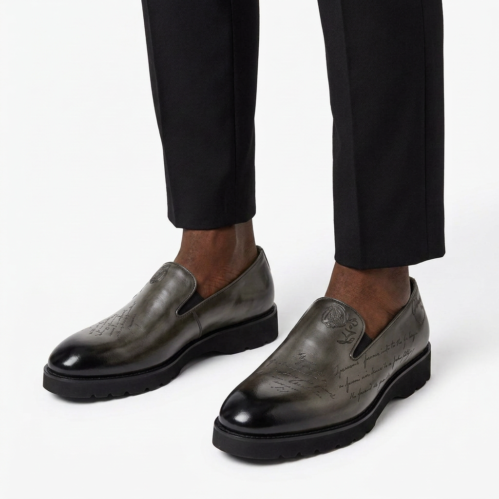 Glossy smoky charcoal-grey script-detail slip-on shoes with darker toes worn on both feet