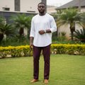 Nigerian male model wearing maroon trousers in outdoor setting