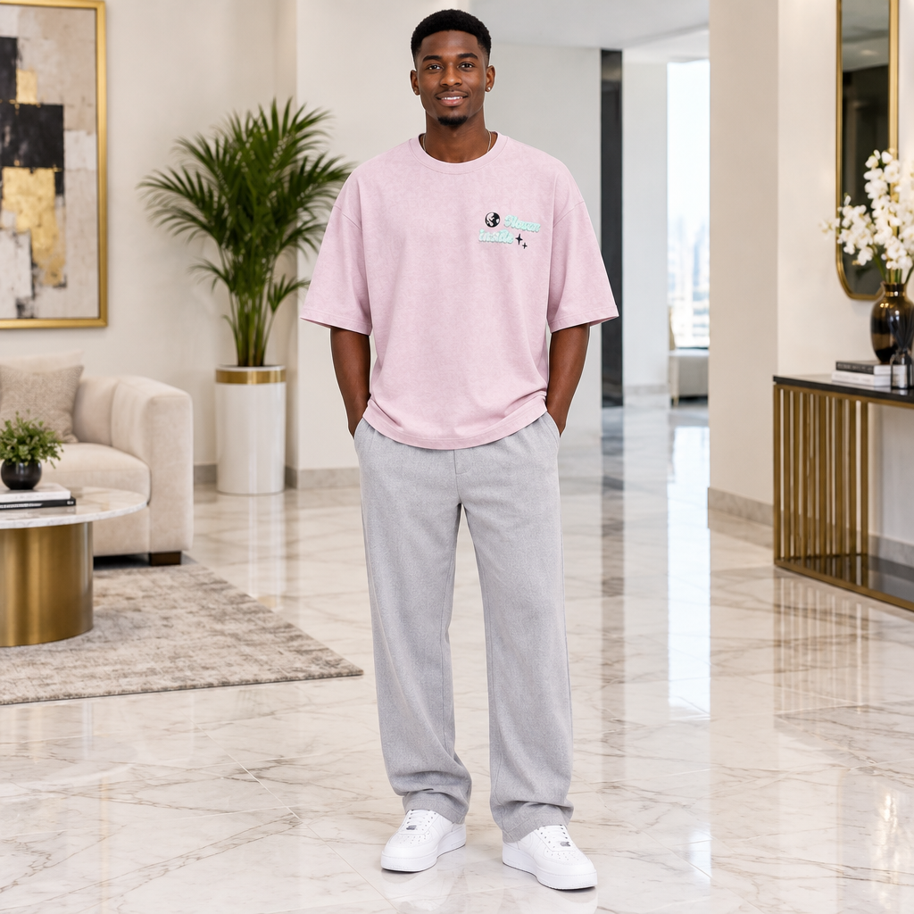 Man wearing soft pink oversized globe script graphic tee
