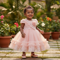 Young Nigerian toddler girl wearing peach rosette lace puff sleeve tulle party dress