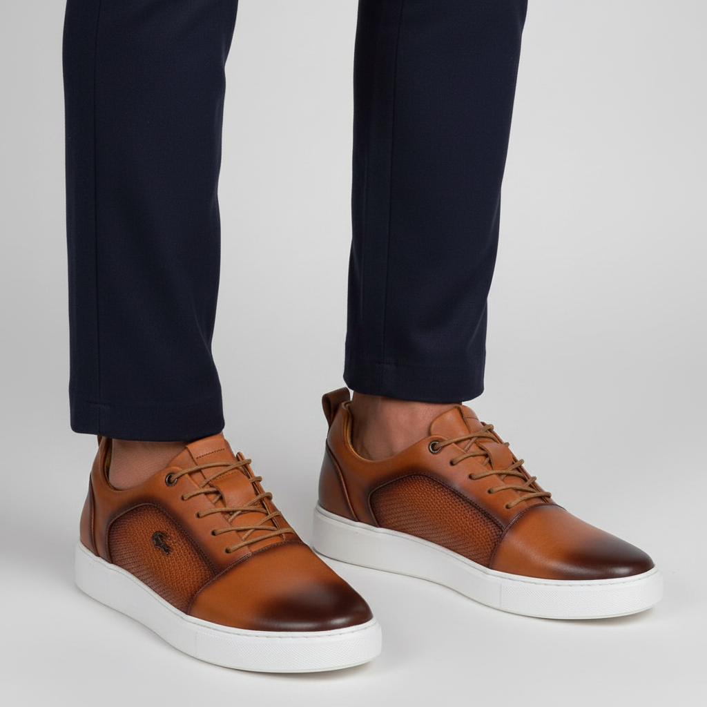 Close-up leg focus showing both men's tan brown leather lace-up sneakers with dark navy trouser hem