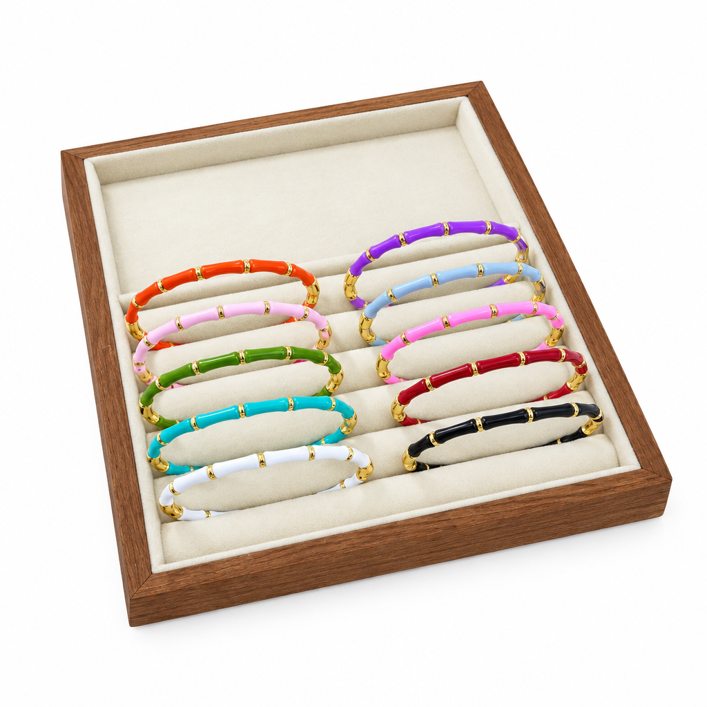 Colourful enamel tube stretch bracelets displayed in a wooden jewelry tray
