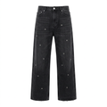 Black wide-leg jeans with scattered silver-tone eyelets and lightly frayed hems