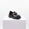 Black patent leather chunky platform loafer on white platform – studio shot