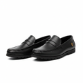 Pair of black leather penny loafers with lug sole on a white background