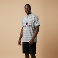 Man wearing grey striped Royal Guard polo shirt with black shorts