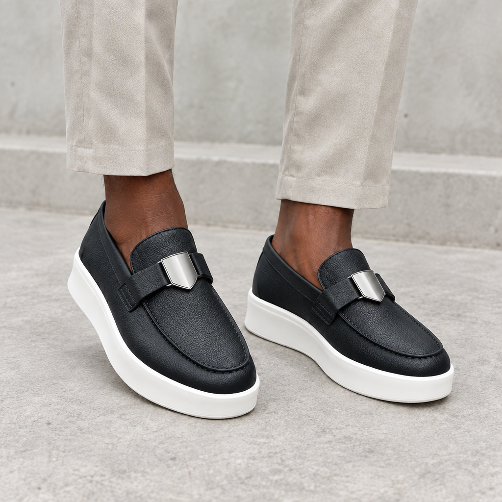 Men's black textured loafers with white soles worn on both feet