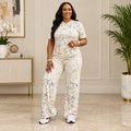 Adult Black woman wearing cream abstract print top and trousers set