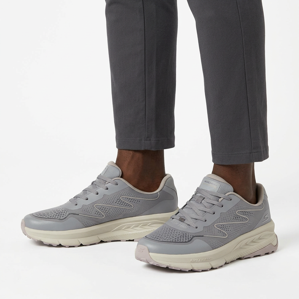 Both grey mesh sneakers worn ankle-down with charcoal trousers