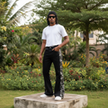 Nigerian male model full body wearing men's black flared denim jeans with grey camo side panels