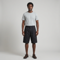Full-body male model wearing black pleated patch-pocket shorts