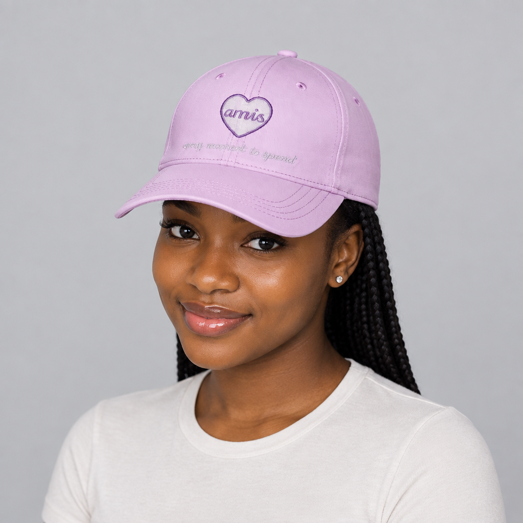 Nigerian woman wearing pink heart-embroidered cap against a plain studio background
