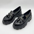 Complete pair of black glossy tassel chunky loafers on a white background