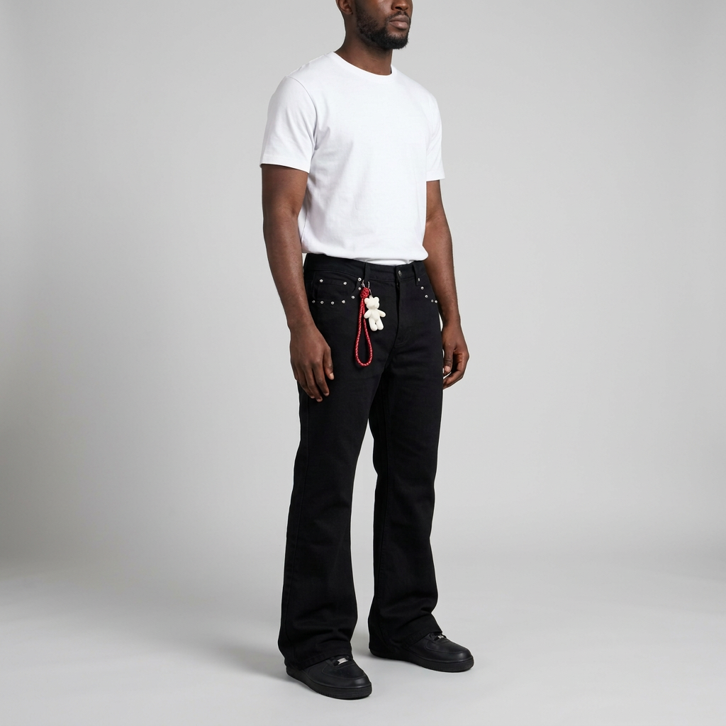 Man wearing black stud detail flared trousers on seamless studio background