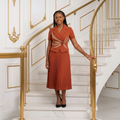 Nigerian teenage girl model wearing terracotta pleated midi dress with rosette detail