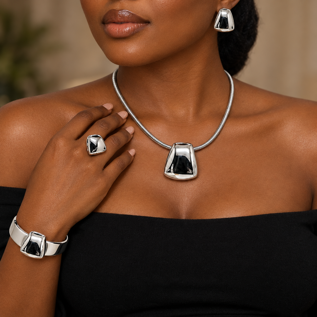 Woman wearing silver sculpted trapeze necklace, earring, ring and bangle set