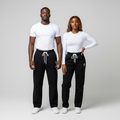 African Nigerian couple wearing unisex black wide-leg sweatpants with embroidered logo