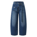 Washed blue wide-leg jeans with long denim belt and asymmetric flap-pocket panel on white