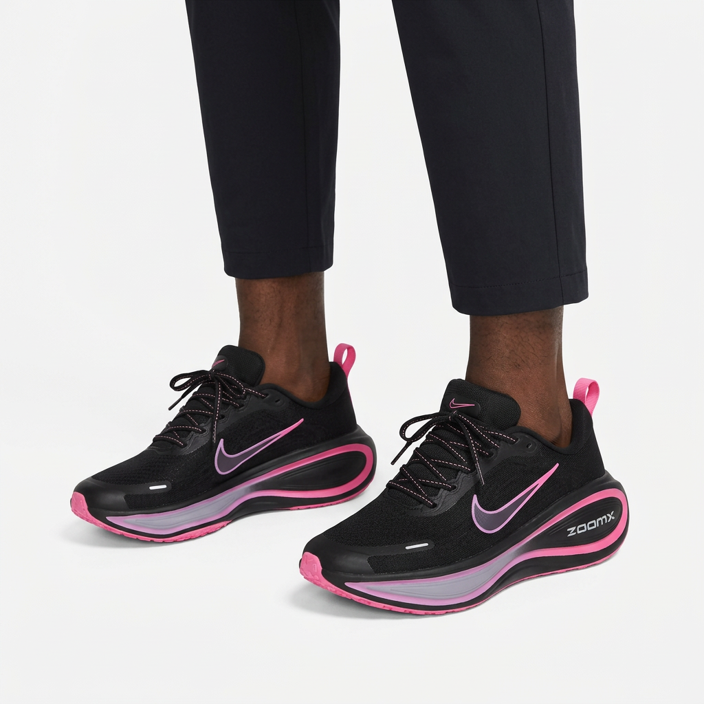 Pair of black pink-trim sneakers properly worn on both feet