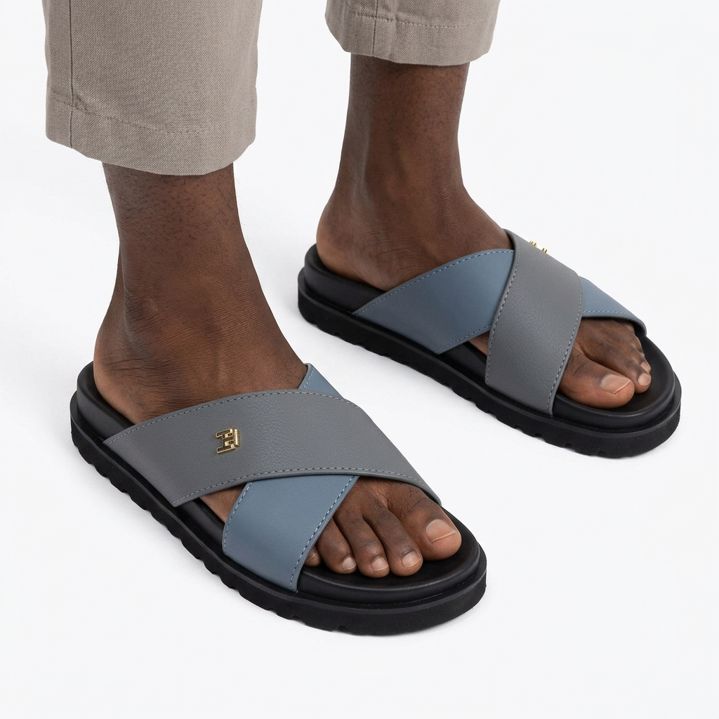 Pair of grey and blue cross-strap slides properly worn on both feet