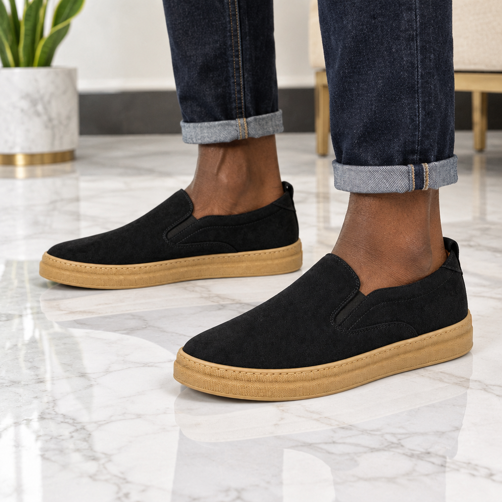 Man wearing black slip-on sneakers with gum sole