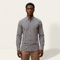 Male model wearing a black and white gingham long-sleeve shirt against a plain off-white background