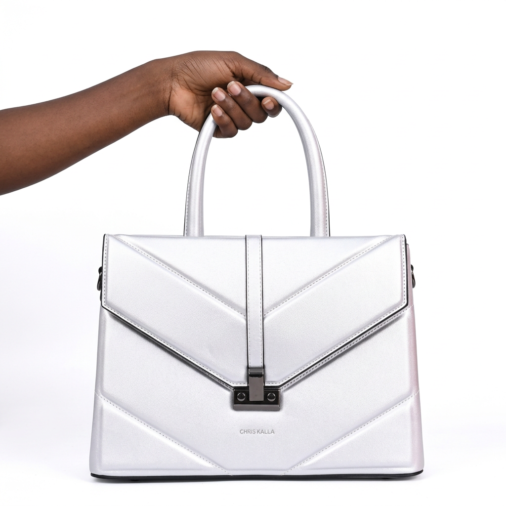 Black woman’s hand holding a white envelope-flap handbag on white