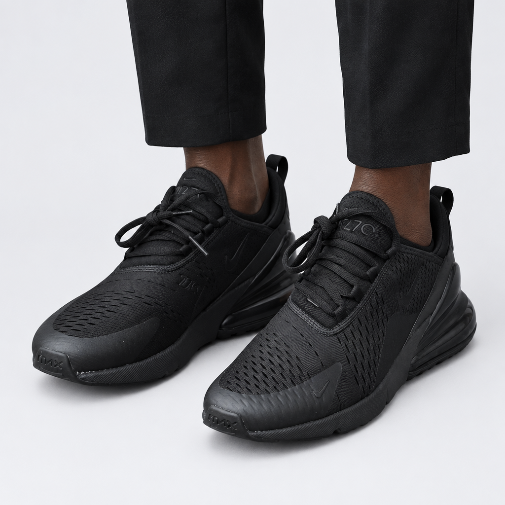 Adult wearing all-black mesh lace-up sneakers