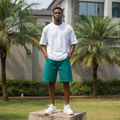Nigerian male model wearing men's teal emerald green wide-leg denim shorts streetwear style