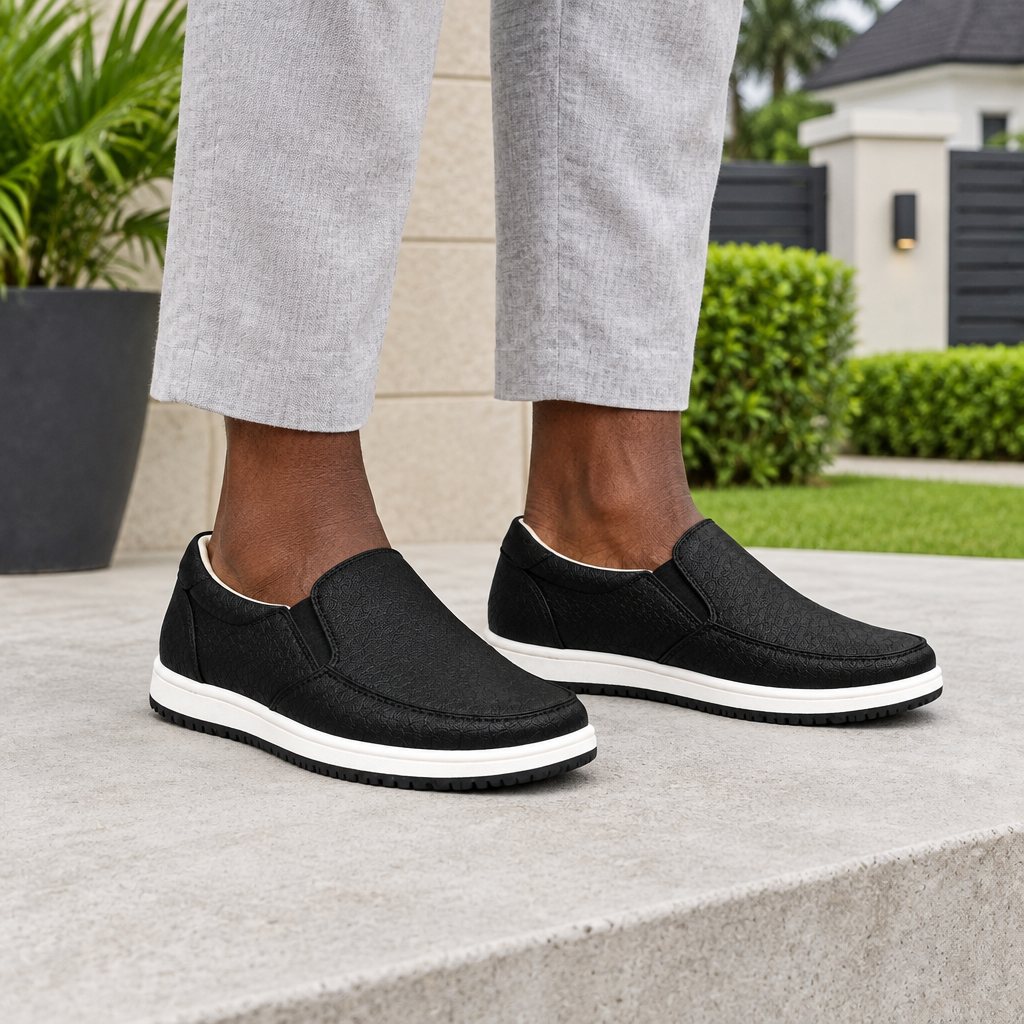 Man wearing black textured slip-on sneakers with grey linen trousers