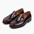 Glossy burgundy penny loafers with moc-toe stitching and low black heels